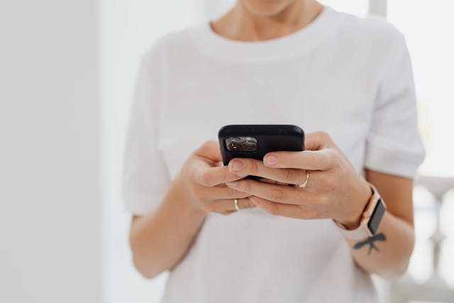 A customer holding a phone while reviewing a business website